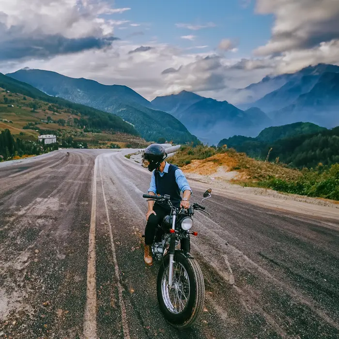 A motorcyclist on a scenic mountain road, ideal for travel and adventure themes.